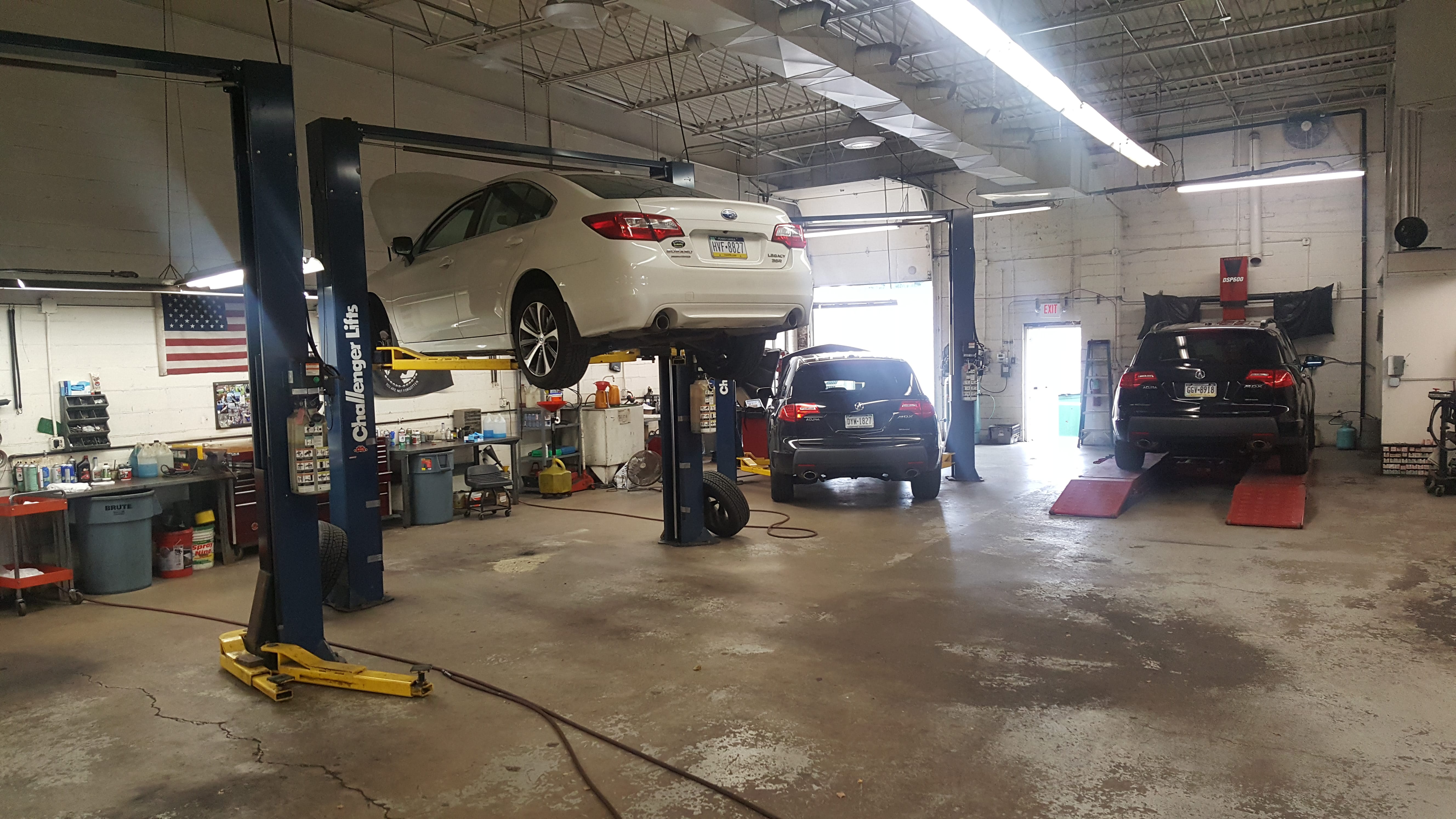 Auto repair service garage with mechanics performing vehicle maintenance and car repair services